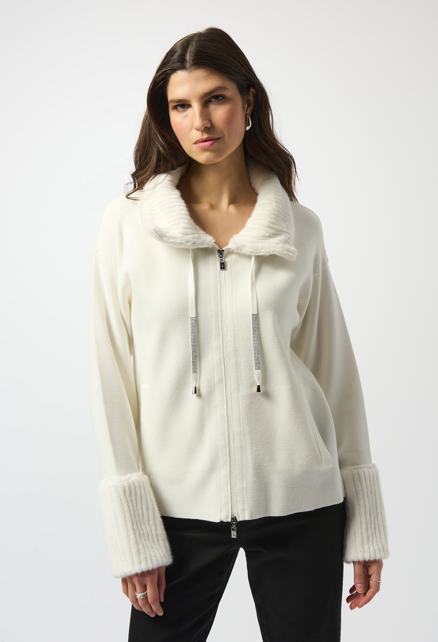 Woman wearing a white zip-up hoodie with fur trim on a white background