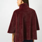 Woman wearing a burgundy cape on a white background