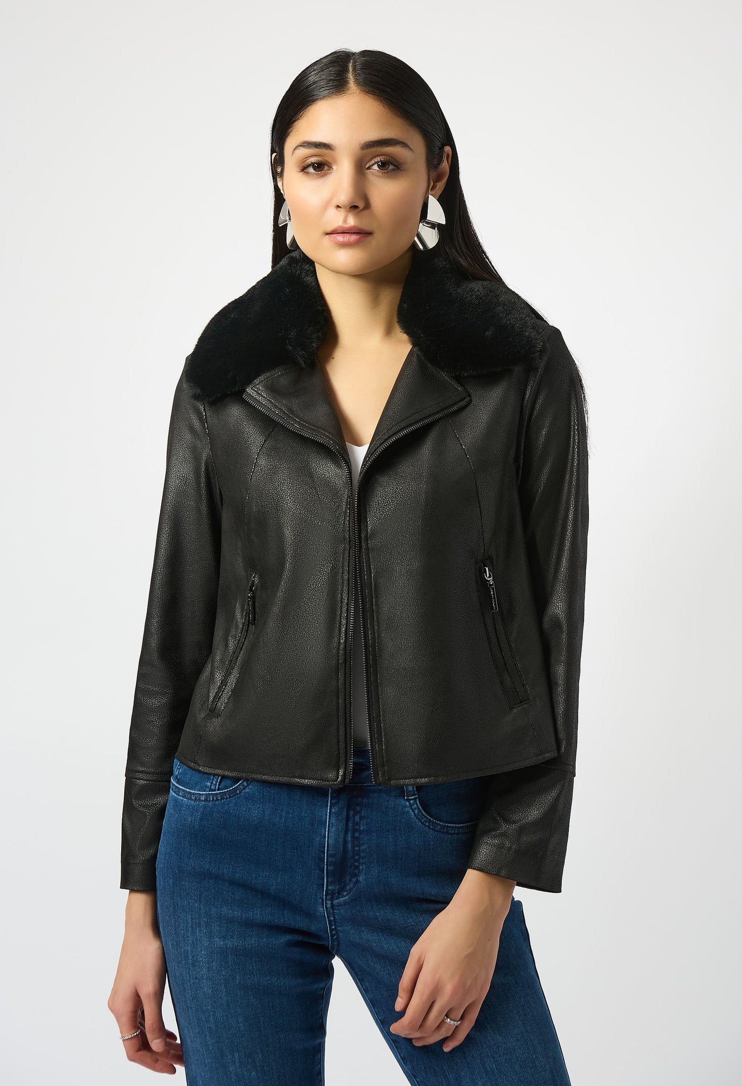 Woman wearing a black leather jacket with fur collar on a white background