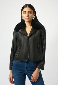 Woman wearing a black leather jacket with fur collar on a white background