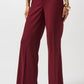 Maroon pants worn by a person on a white background