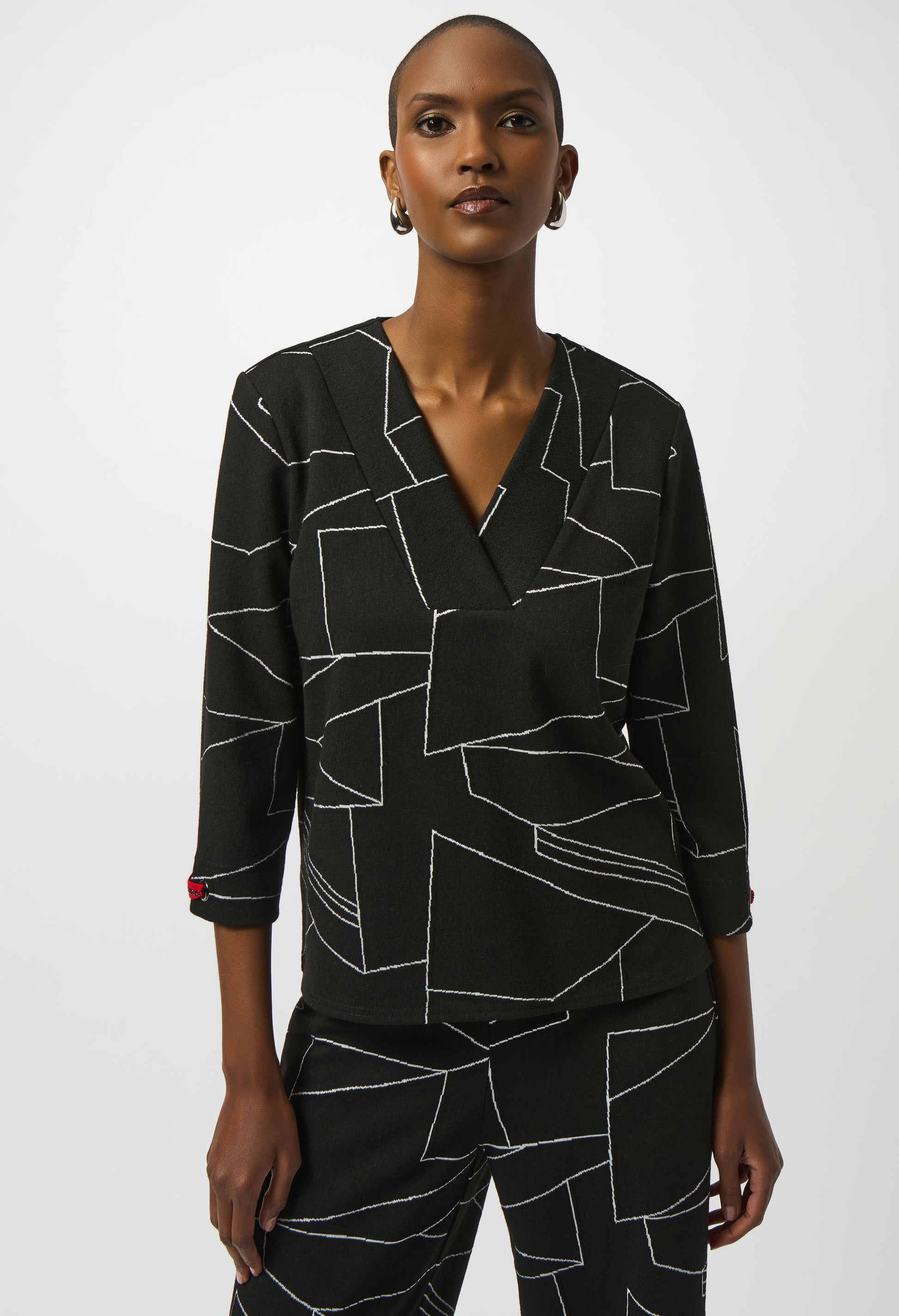 Woman wearing a black geometric patterned outfit on a white background