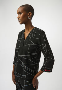 Woman wearing a black dress with geometric pattern on a white background