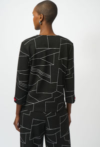 Person wearing a black outfit with geometric pattern on a white background