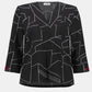 Black blouse with white geometric pattern on a white background