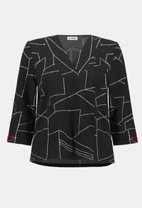 Black blouse with white geometric pattern on a white background