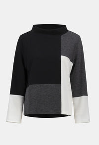 Color-blocked sweater with black, gray, and white sections on a light gray background