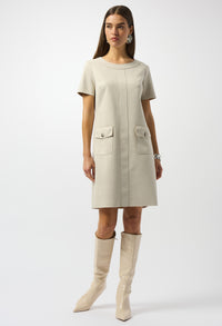 Woman wearing a beige dress with pocket details on a white background