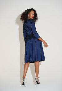 Woman wearing a blue dress with fringe details against a white background