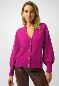 Woman wearing a bright pink cardigan on a white background