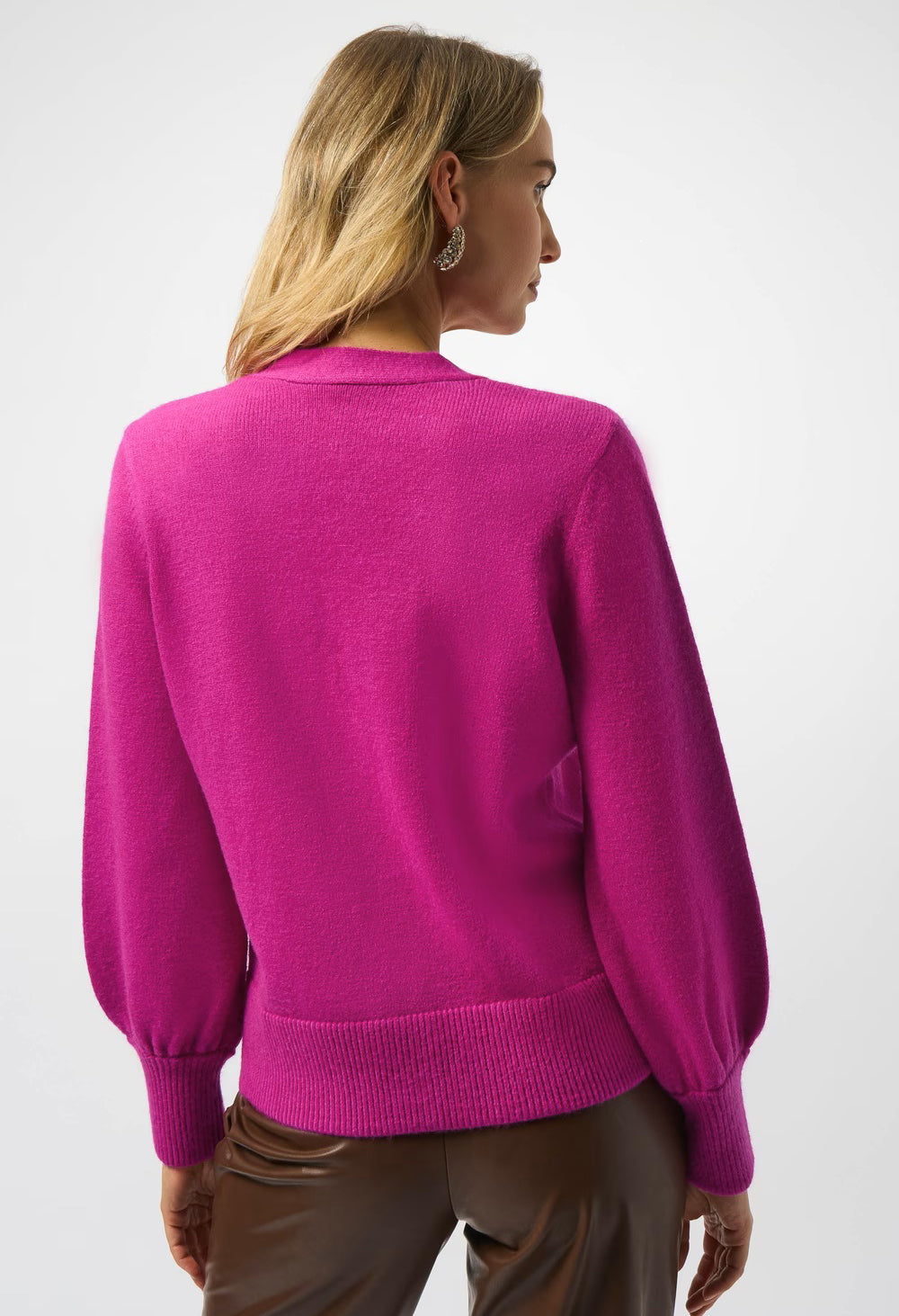 Person wearing a bright pink sweater on a white background