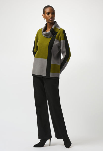 Woman wearing a color-blocked sweater and black pants on a white background