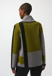 Person wearing a green, gray, and black color-blocked sweater on a white background
