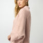 Woman wearing a pink sweater against a white background