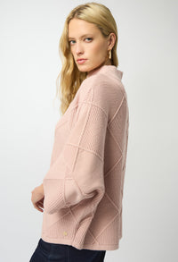 Woman wearing a pink sweater against a white background