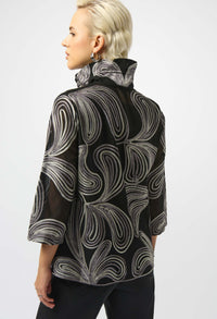 Person wearing a black and gray patterned jacket on a white background