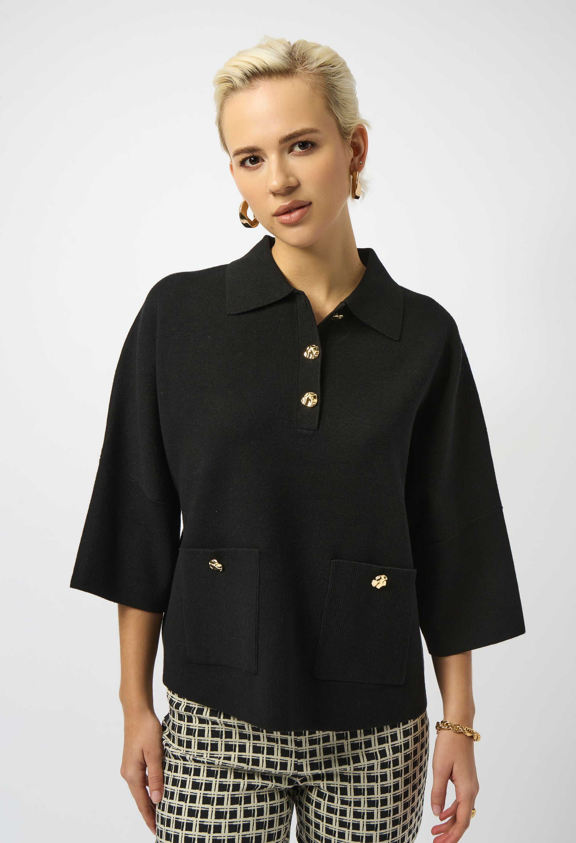 Woman wearing a black jacket with gold buttons on a white background