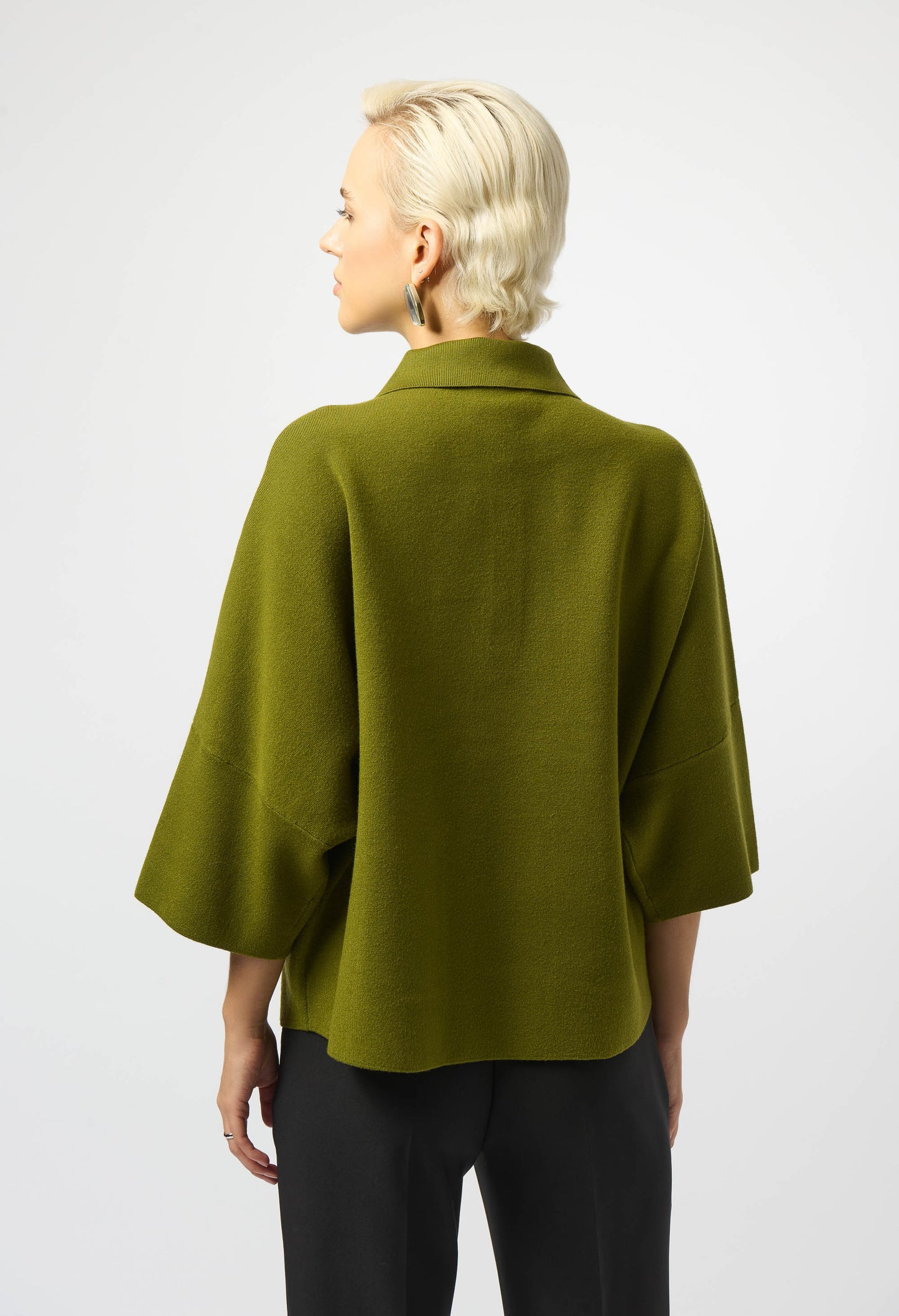 Person wearing a green cape on a white background
