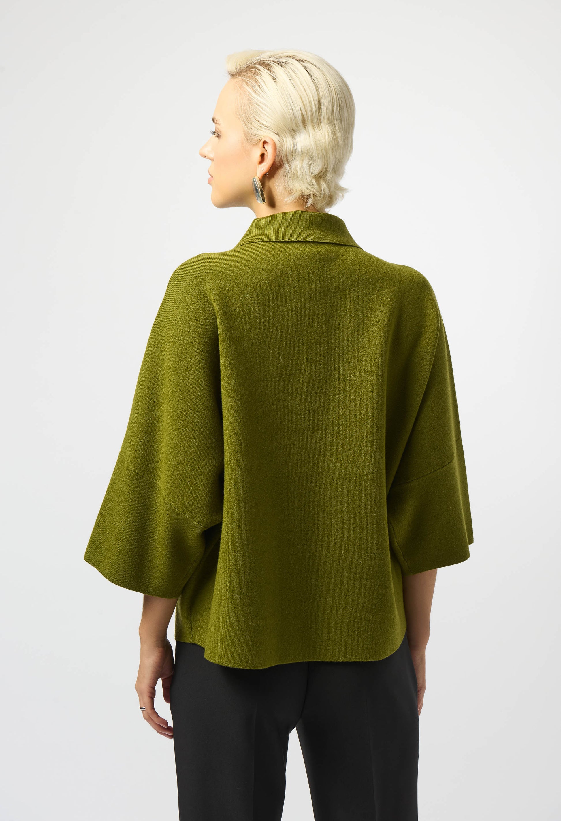 Person wearing a green cape on a white background