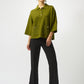 Woman wearing a green blouse and black pants on a white background