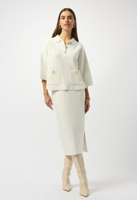 Woman wearing a white suit with beige knee-high boots on a white background