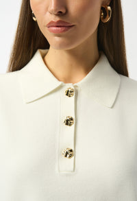 Close-up of a white blouse with gold buttons on a plain background