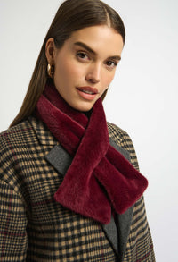Woman wearing a red scarf and plaid coat on a white background