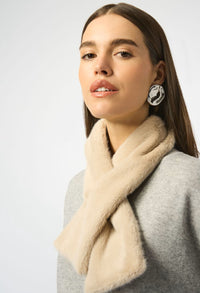 Woman wearing a beige scarf and earrings on a white background