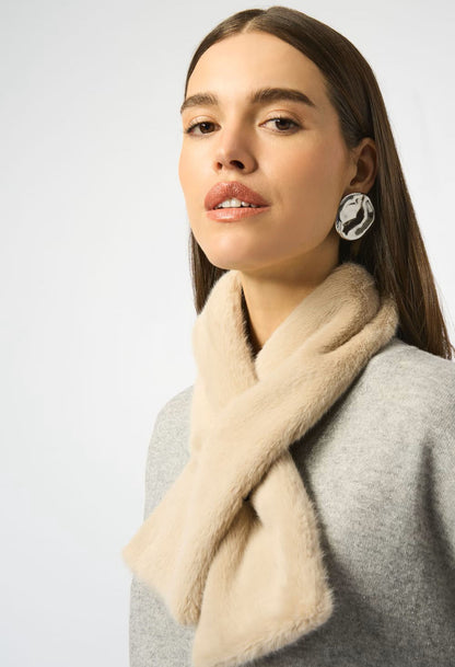 Woman wearing a beige scarf and earrings on a white background