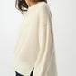 Woman wearing a cream sweater on a white background