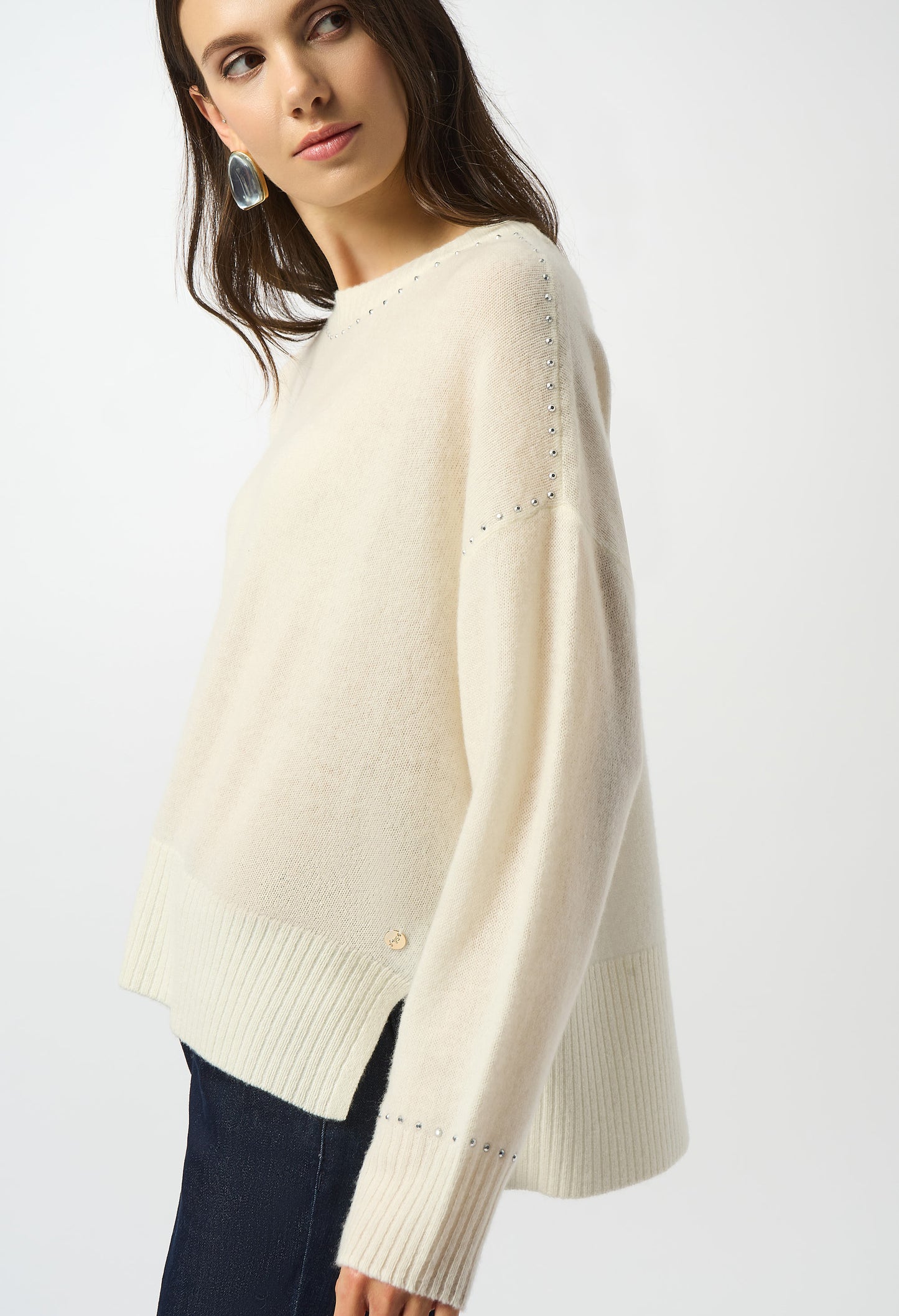 Woman wearing a cream sweater on a white background