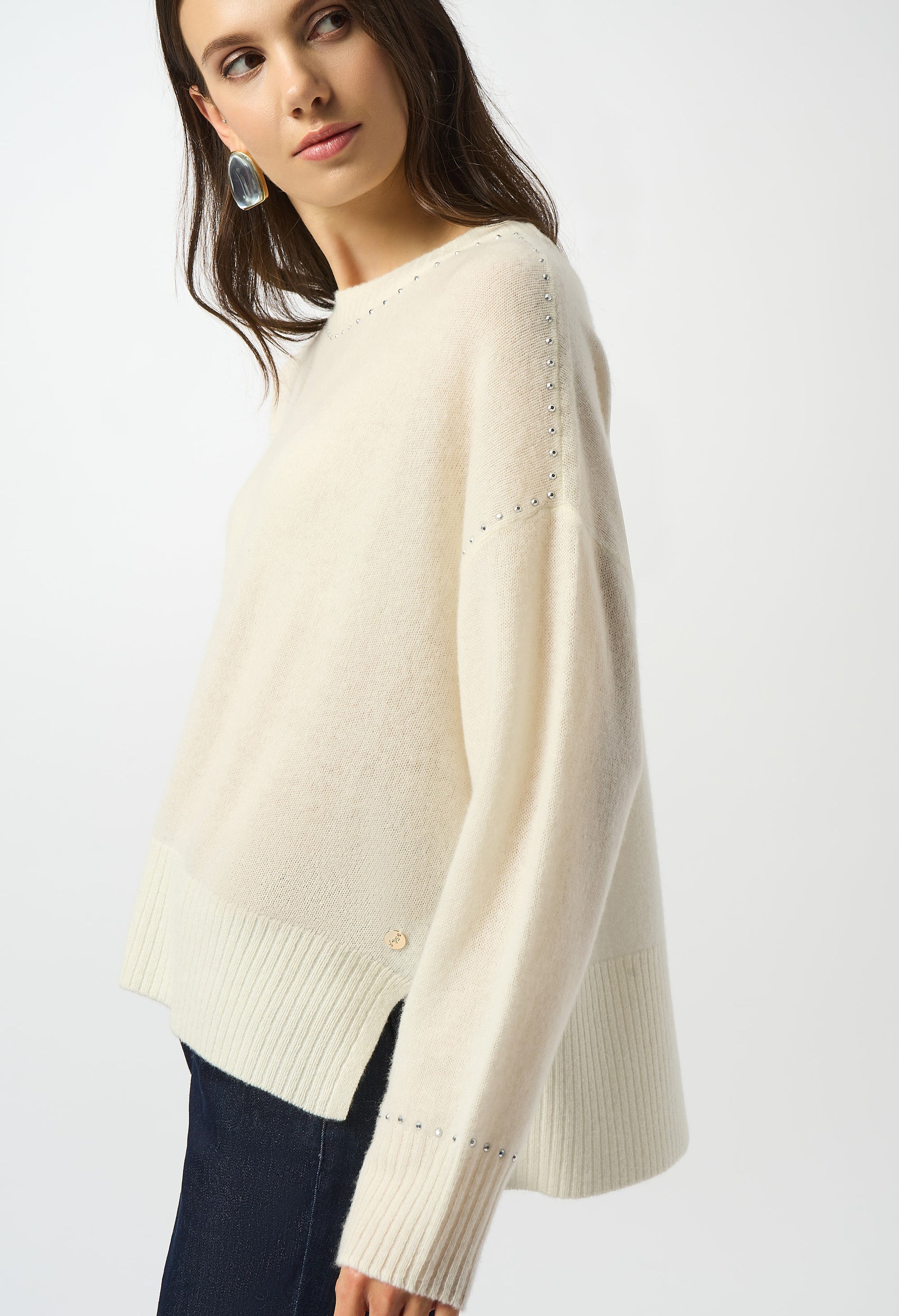 Woman wearing a cream sweater on a white background