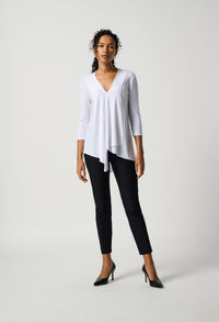 Woman wearing a white top and black pants on a white background