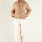Woman wearing a beige puffer jacket on a white background