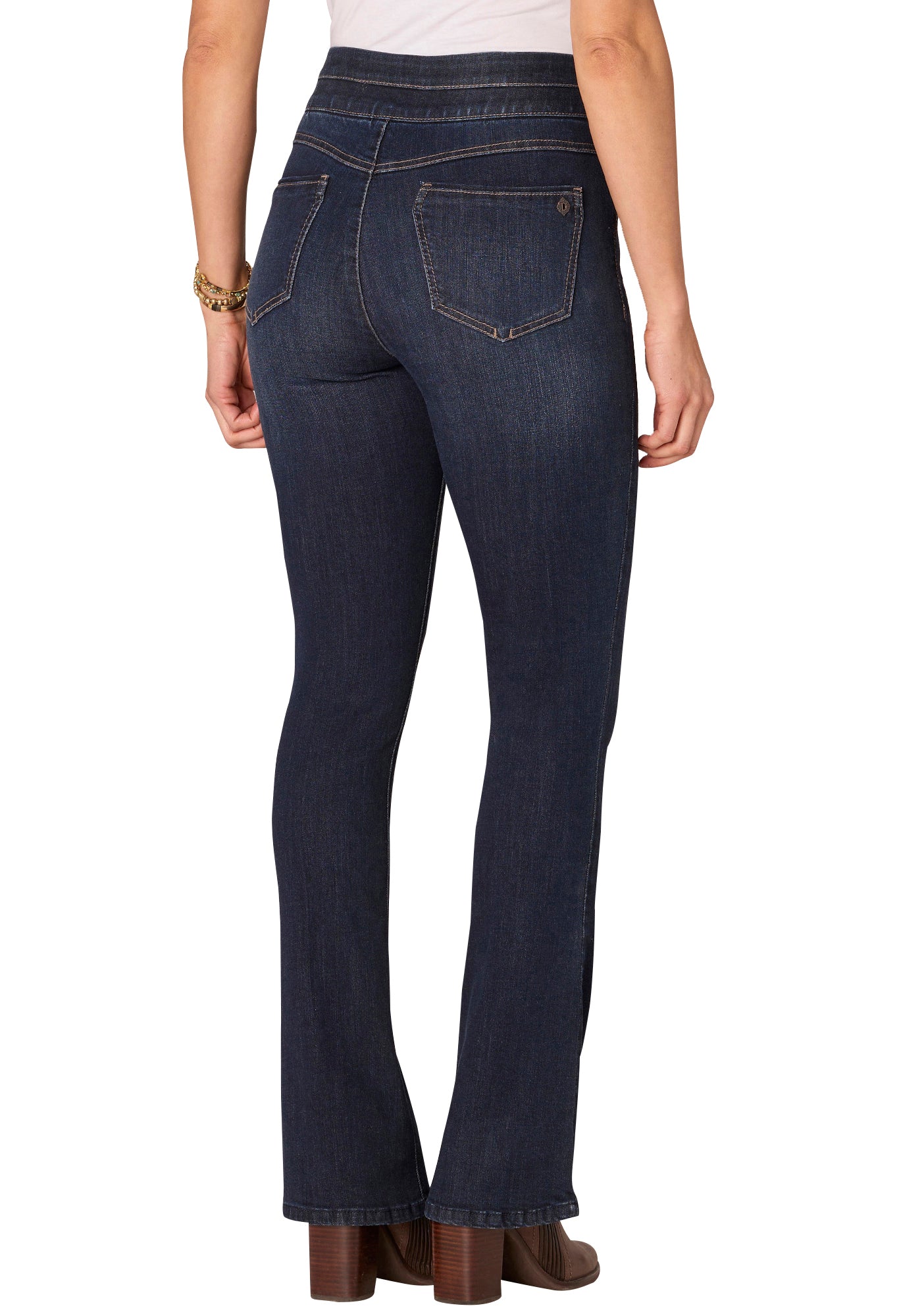 Dark blue jeans worn by a person on a white background