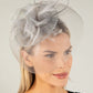 Woman wearing a decorative headpiece with a veil against a neutral background