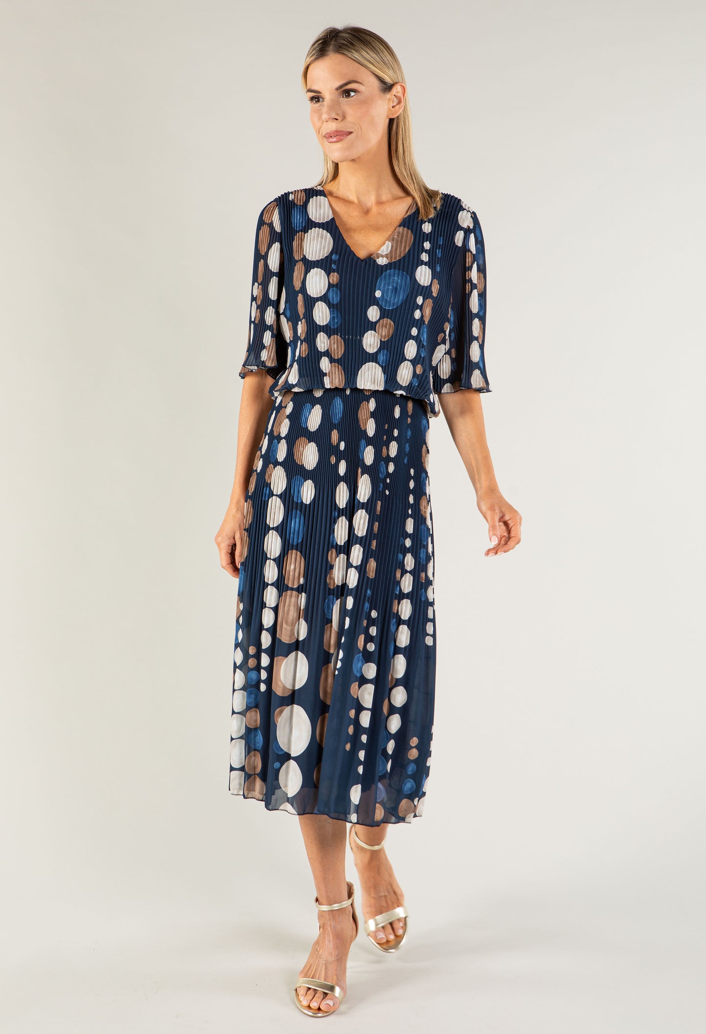 Woman wearing a blue polka dot dress on a white background