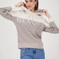 Woman wearing a gray hoodie with 'BEAUTY' text and blue jeans on a white background