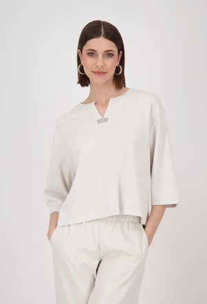 Woman wearing a white outfit with a plain background