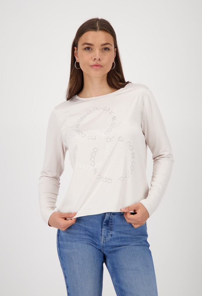 Woman wearing a white sweater with lace details and blue jeans on a white background