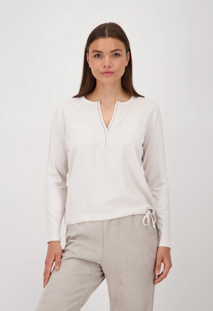 Woman wearing a white blouse and beige pants on a white background