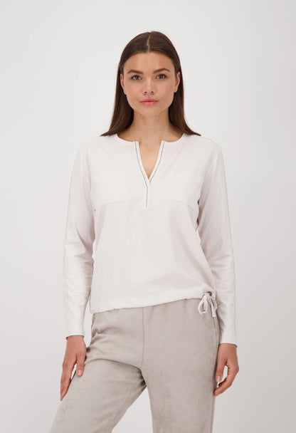 Woman wearing a white blouse and beige pants on a white background