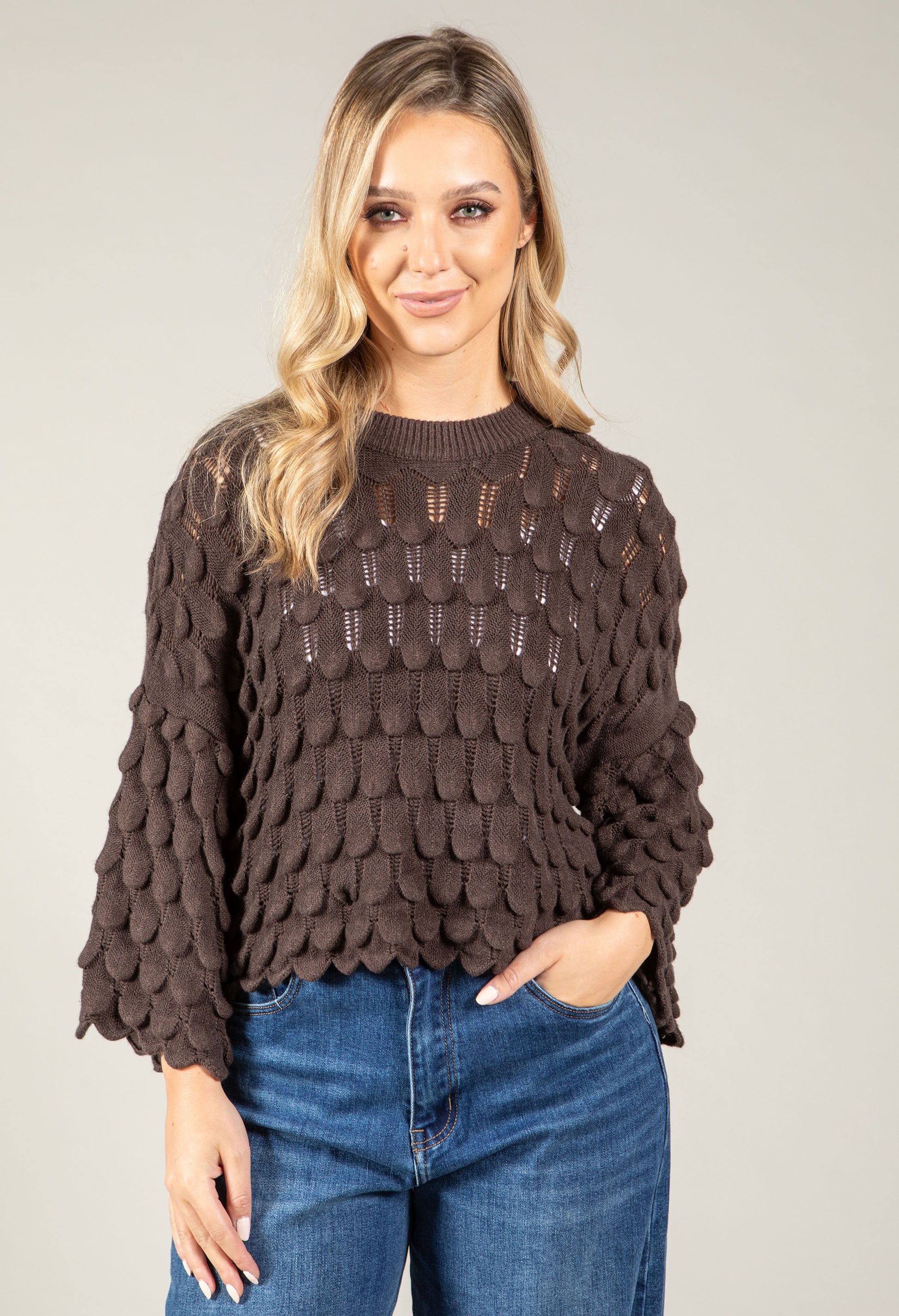 woman wearing a chocolate brown scalloped knit jumper