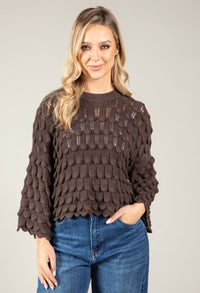 woman wearing a chocolate brown scalloped knit jumper