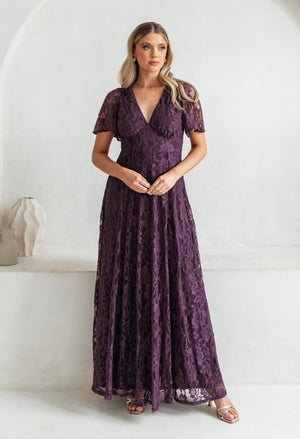 Woman wearing a purple lace dress against a white background