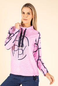 Woman wearing a pink hoodie with black graphics on a beige background