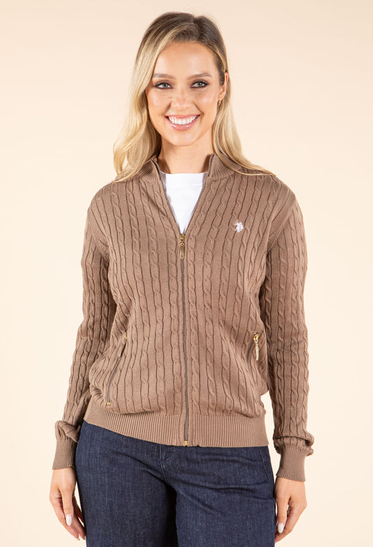Woman wearing a purple cable knit cardigan on a beige background