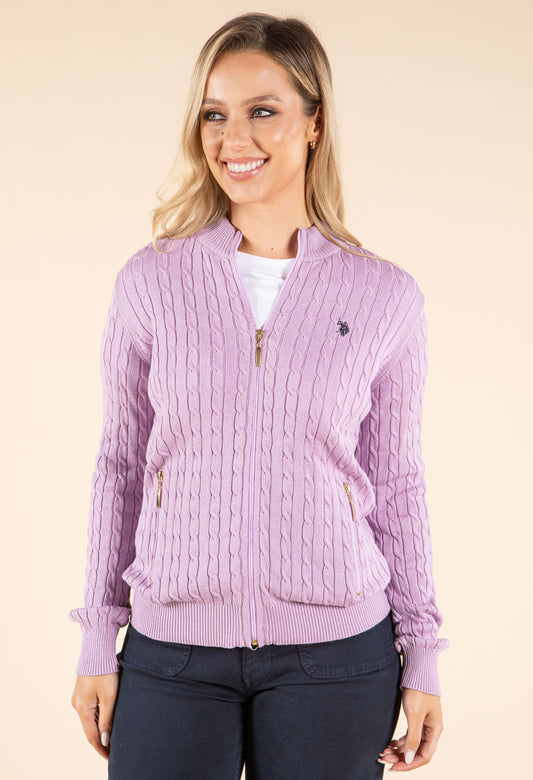 Woman wearing a purple cable knit cardigan on a beige background