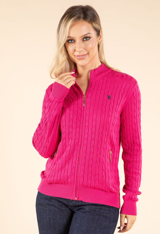 Woman wearing a purple cable knit cardigan on a beige background