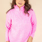 Woman wearing a pink pullover with a zipper on a beige background